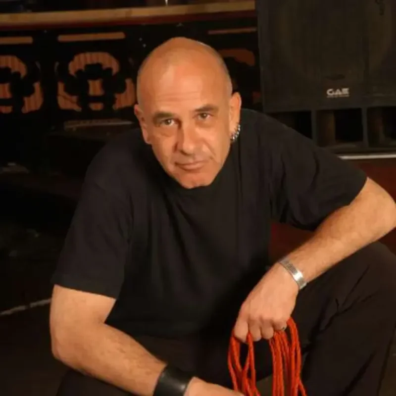Matthias T.J. Grimme sitzt in schwarzem T-Shirt und hält ein rotes Seil in der Hand