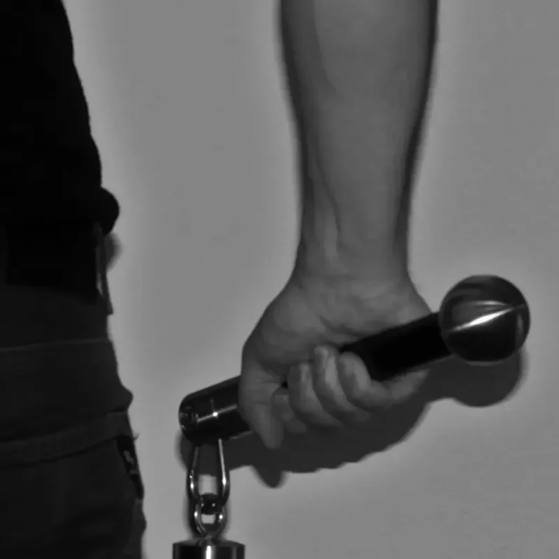 Hand hält ein Mikrofon mit Vorhängeschloss vor grauem Hintergrund