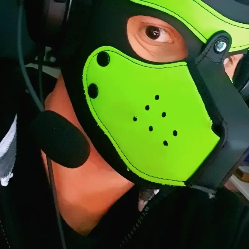 Nahaufnahme einer Person mit neongrüner Gesichtsmaske und Headset-Mikrofon